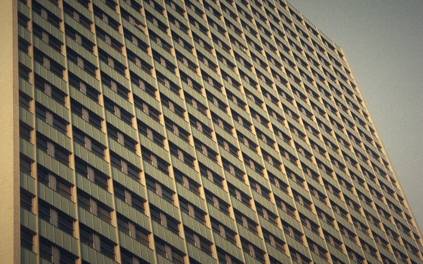 Repeating grid of small windows covers the facade of a tall high-rise building
