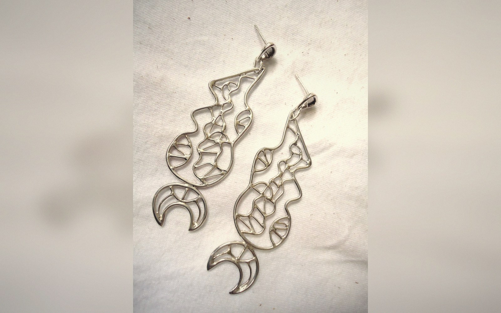 Pair of silver filigree earrings with crescent moon and geometric wire designs