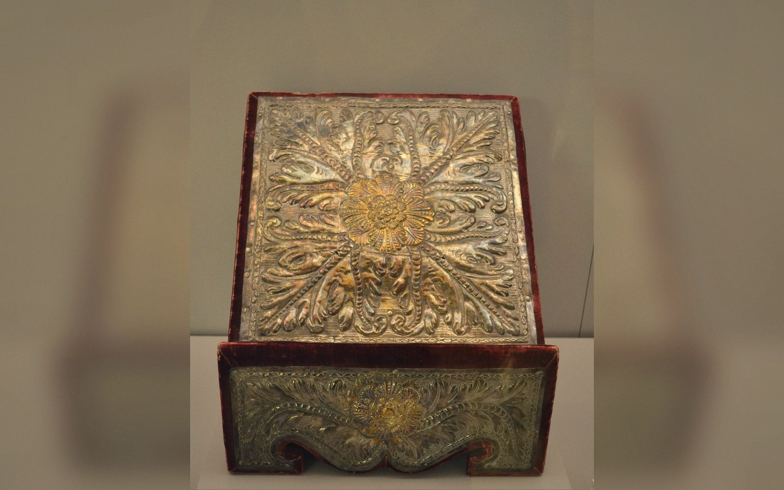 Ornate embossed silver lectern panel with floral and foliate repoussé design on velvet mount