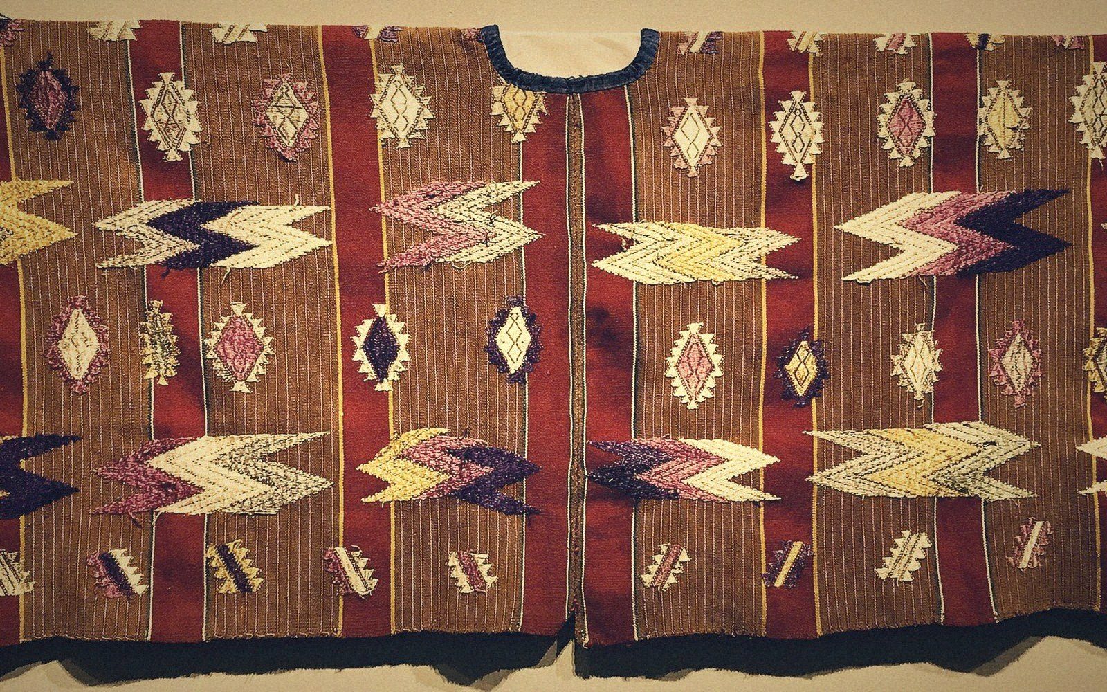 Woven textile with diamond and zigzag motifs in red, brown, cream and purple stripes