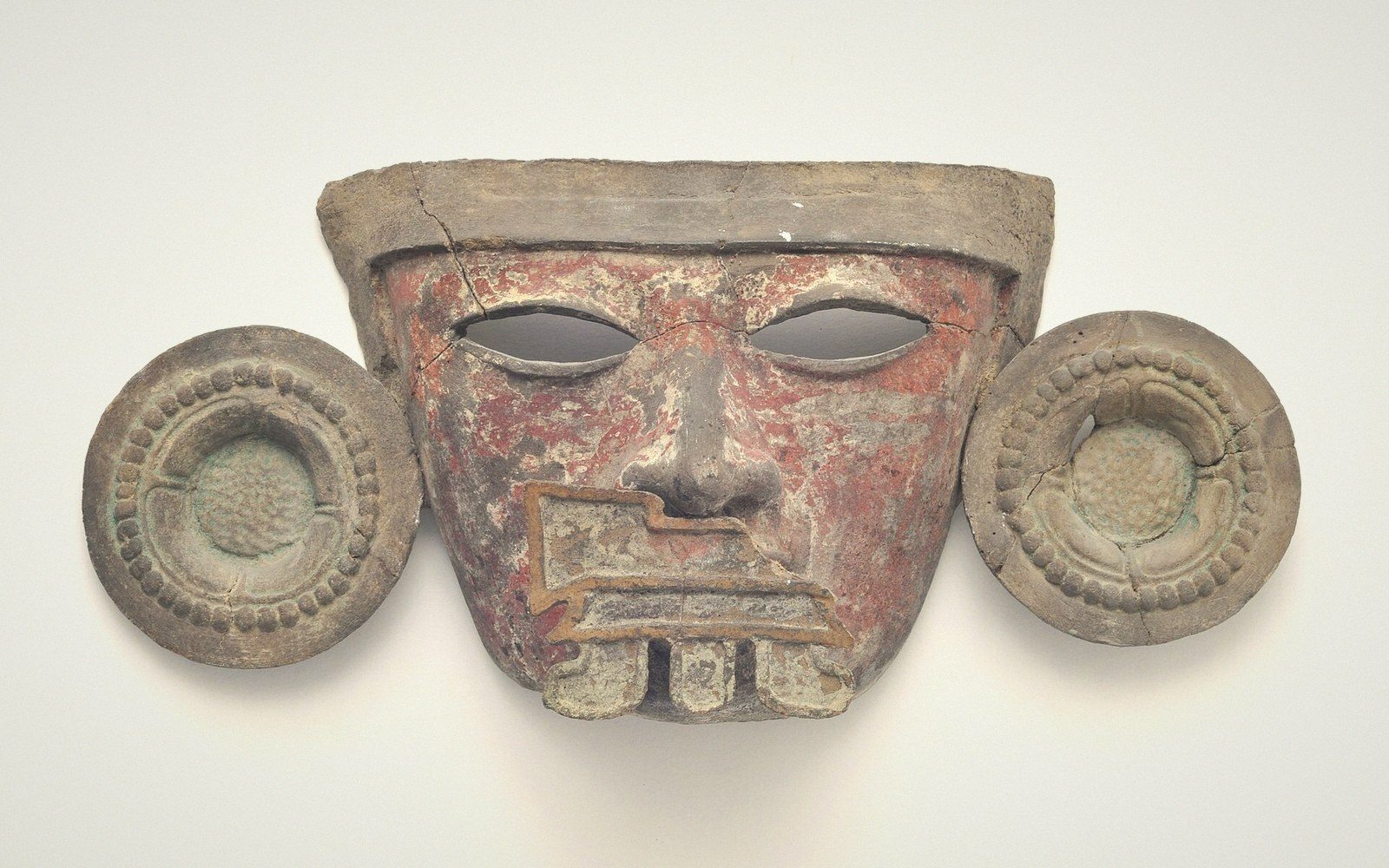A painted festival mask on a plain ground